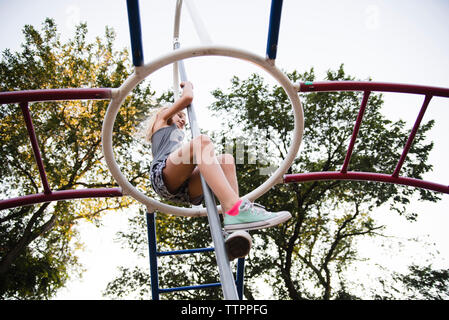 Low Angle View von Mädchen klettern an der Monkey Bars gegen Sky Stockfoto