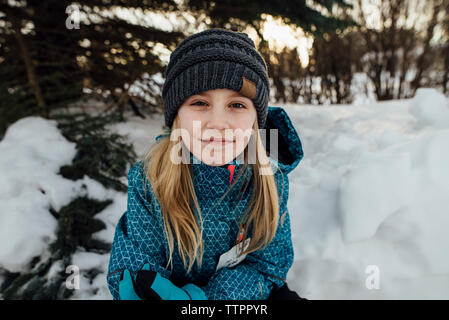 Portrait von Mädchen sitzen auf Schnee Stockfoto