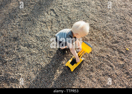 Hohe Betrachtungswinkel der Junge spielt mit Spielzeug earthmover auf dem Boden Stockfoto