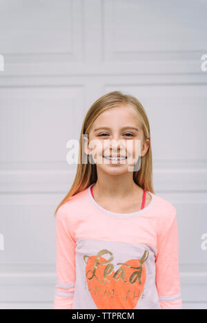 Porträt der lächelnde Mädchen stehend gegen Tür Stockfoto