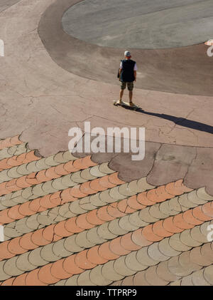 Hohen winkel Menschenbild skateboarding auf der Straße in der Stadt während der sonnigen Tag Stockfoto