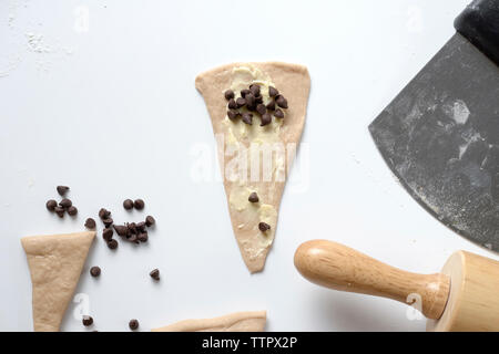 Ansicht von oben der Schokolade Chips auf Teig am Tisch Stockfoto