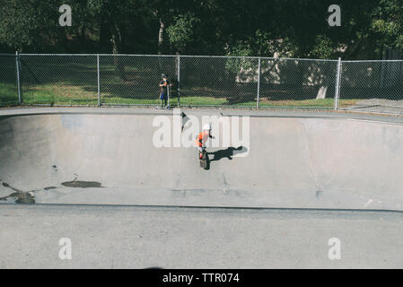 Junge während Bruder skateboarding auf Sport Rampe im Park Stockfoto