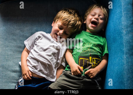 Hohe Betrachtungswinkel der glücklichen Brüder auf dem Sofa zu Hause liegen Stockfoto