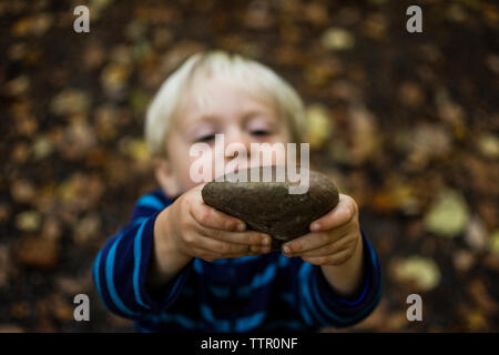 Hohe Betrachtungswinkel der Boy holding Stein Stockfoto