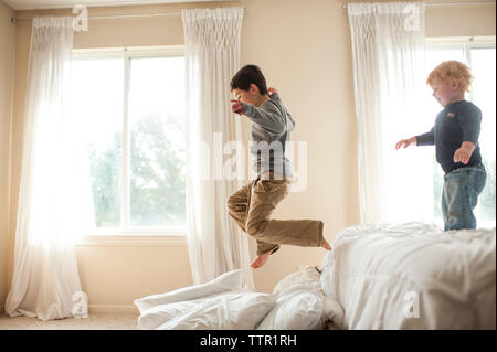 Bruder Spaß springen Bett in Kissen im Schlafzimmer Stockfoto