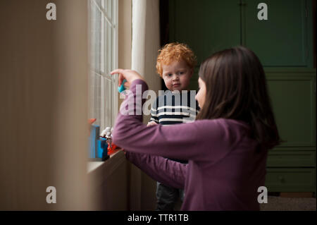 Kleinen Bruder aufpassen grosse Schwester spielen mit Spielzeug zu Hause Stockfoto