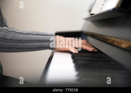 Zugeschnittenes Bild der älteren Frau, die Klavier spielen zu Hause Stockfoto