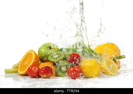 Gemüse und Früchte mit Spritzwasser auf weißem Hintergrund Stockfoto