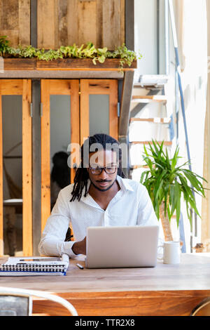 Junge Unternehmer mit Laptop auf dem Schreibtisch in der kreativen Büro Stockfoto