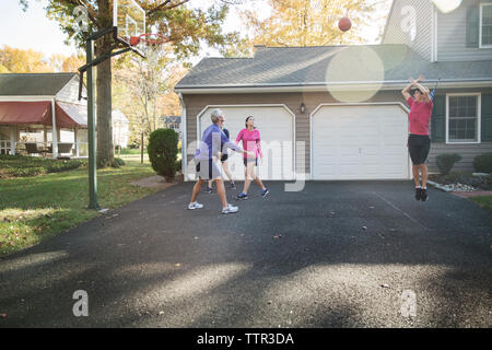 Familie Basketball spielen im Garten an einem sonnigen Tag Stockfoto