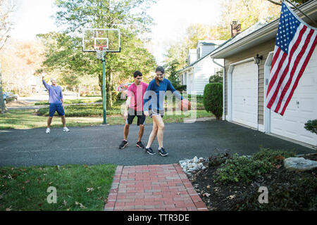 Happy Family spielen Basketball im Hinterhof Stockfoto