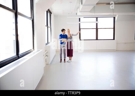 Immobilienmakler erklärt neue Bürobereich zu Geschäftsfrau Stockfoto
