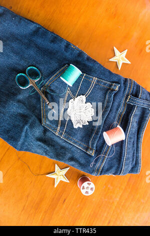 Hohe Betrachtungswinkel von Jeans mit nähen Elemente auf dem Tisch zu Hause Stockfoto