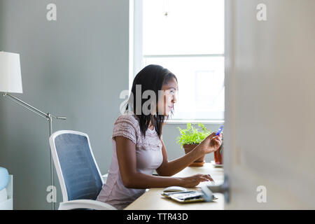 Frau zu Hause arbeiten Büro durch Tür gesehen Stockfoto