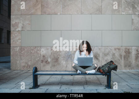 Junge Frau mit Laptop auf der Werkbank Stockfoto