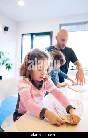 Vater Kinder bei der Vorbereitung der Teig bei Tisch in Home Unterstützung Stockfoto