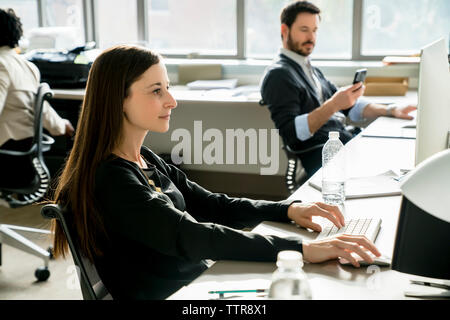 Geschäftsleute, die am Schreibtisch im Büro arbeiten Stockfoto
