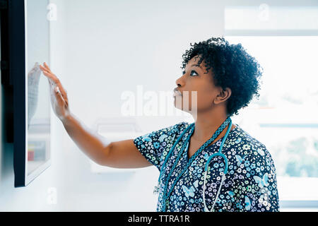 Ärztin berühren Flachbildschirm während im Krankenhaus zu arbeiten Stockfoto