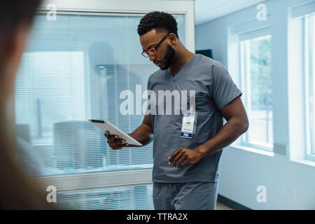 Arzt mit Tablet-PC beim Gehen im Krankenhaus Stockfoto