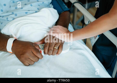 Nahaufnahme der Krankenschwester, die Berührung der Hand des älteren Patienten im Krankenhaus Stockfoto