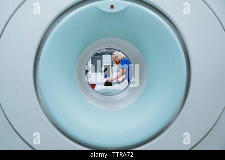 Krankenschwester Vorbereitung der Patienten auf die MRT-Scan im Krankenhaus durch Scanner gesehen Stockfoto