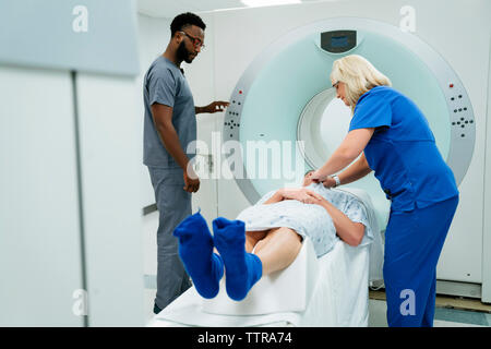 Arzt, Krankenschwester, Vorbereitung für die MRT-Untersuchung am Patienten im Untersuchungsraum Stockfoto