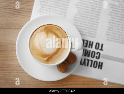 Tasse frischen Kaffee und die Morgenzeitung auf hölzernen Tisch Stockfoto