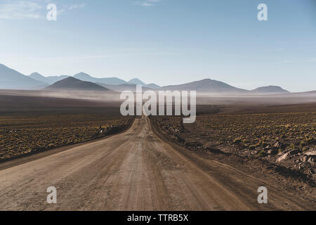 Malerischer Blick auf die unbefestigte Straße inmitten der Atacama Wüste gegen Sky Stockfoto
