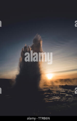 Geysir Ausbruch gegen Himmel bei Sonnenuntergang Stockfoto