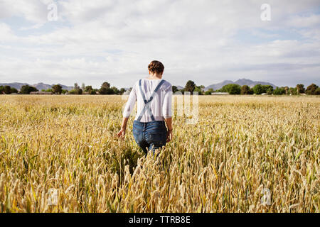 Ansicht der Rückseite des weiblichen Betriebsinhaber zu Fuß auf bebautes Feld Stockfoto