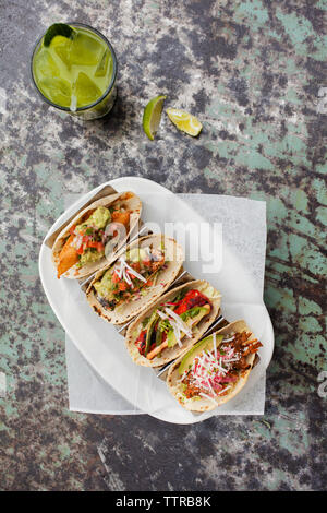 Ansicht von oben der Tacos mit Margarita am Tisch serviert Stockfoto