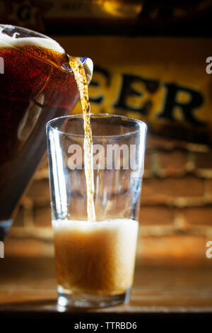 Bier von Krug in Glas gegossen Stockfoto