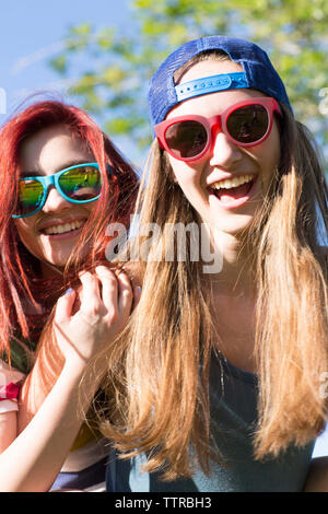 Low Angle Portrait von Happy weibliche Freunde bei Sonnenbrillen Stockfoto