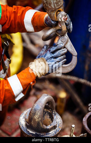 Zugeschnittenes Bild der Arbeiter Holding metallischer Haken Stockfoto