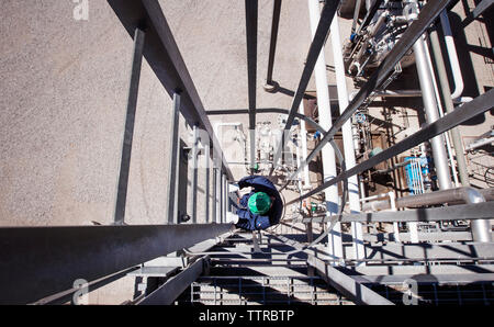 Ansicht von oben von Worker klettern Treppe bei Power Station Stockfoto