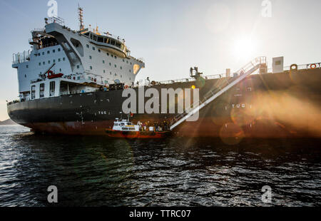 Container schiff im Meer gegen Himmel während der sonnigen Tag Stockfoto