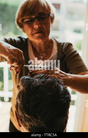 Weibliche friseur Haare schneiden von männlichen Kunden Stockfoto