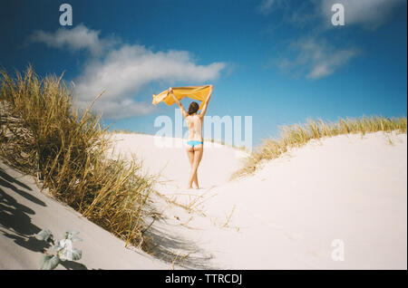 Ansicht der Rückseite Frau mit Decke am Strand in den Sommerferien Stockfoto