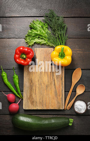 Frisches Gemüse um Cutting Board auf Holz- Hintergrund Stockfoto