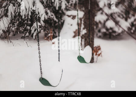 Schaukeln über Schnee hängen auf Spielplatz im Winter Stockfoto