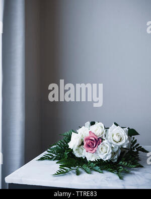 Rose Blumenstrauß auf dem Tisch gegen die Wand zu Hause Stockfoto