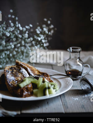 In der Nähe der süßen Brote mit Kiwi in der Platte am Tisch serviert Stockfoto