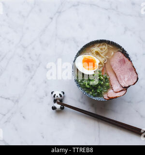 Hohe Betrachtungswinkel der Ramen Nudeln Suppe mit Schweinefleisch in Schüssel auf Zähler serviert. Stockfoto