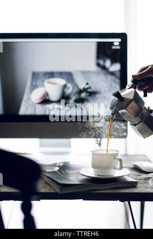 7/8 Bild der Frau Kaffee in der Tasse gießen Stockfoto