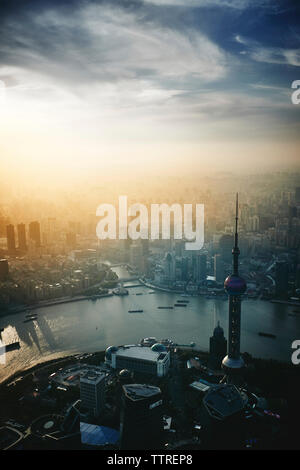 Luftaufnahme der modernen Stadtbild durch den Fluss Huangpu gegen bewölkter Himmel bei Sonnenuntergang Stockfoto