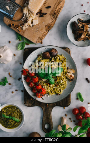 Ansicht von oben der gekochten Spaghetti auf Schneidebrett mit Zutaten Stockfoto