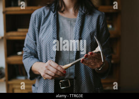 Mittelteil der weiblichen Polsterer holding Hammer beim Stehen in der Werkstatt Stockfoto