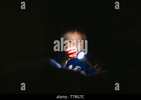 Junge spielt mit Taschenlampe in der Dunkelkammer Stockfoto