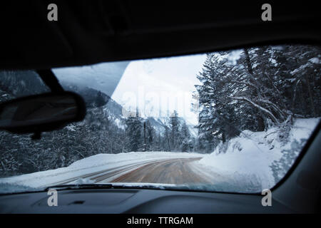 Straße durch Auto Windschutzscheibe im Winter gesehen Stockfoto